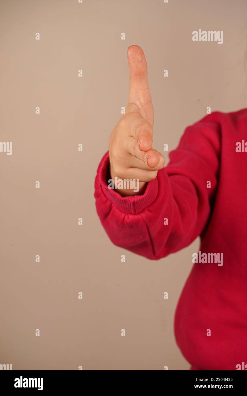 Indicizza e medio dita rivolte verso l'esterno e le due dita inferiori sono piegate nel palmo. Pollice in mano. La mano che punta come una pistola Foto Stock