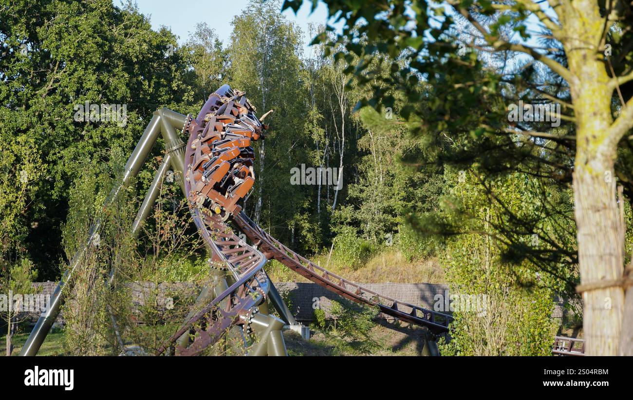 I giovani si divertono sulla curva delle montagne russe di lancio intense «Toutatis» del produttore «Intamin» nel parco tematico «Asterix» Foto Stock