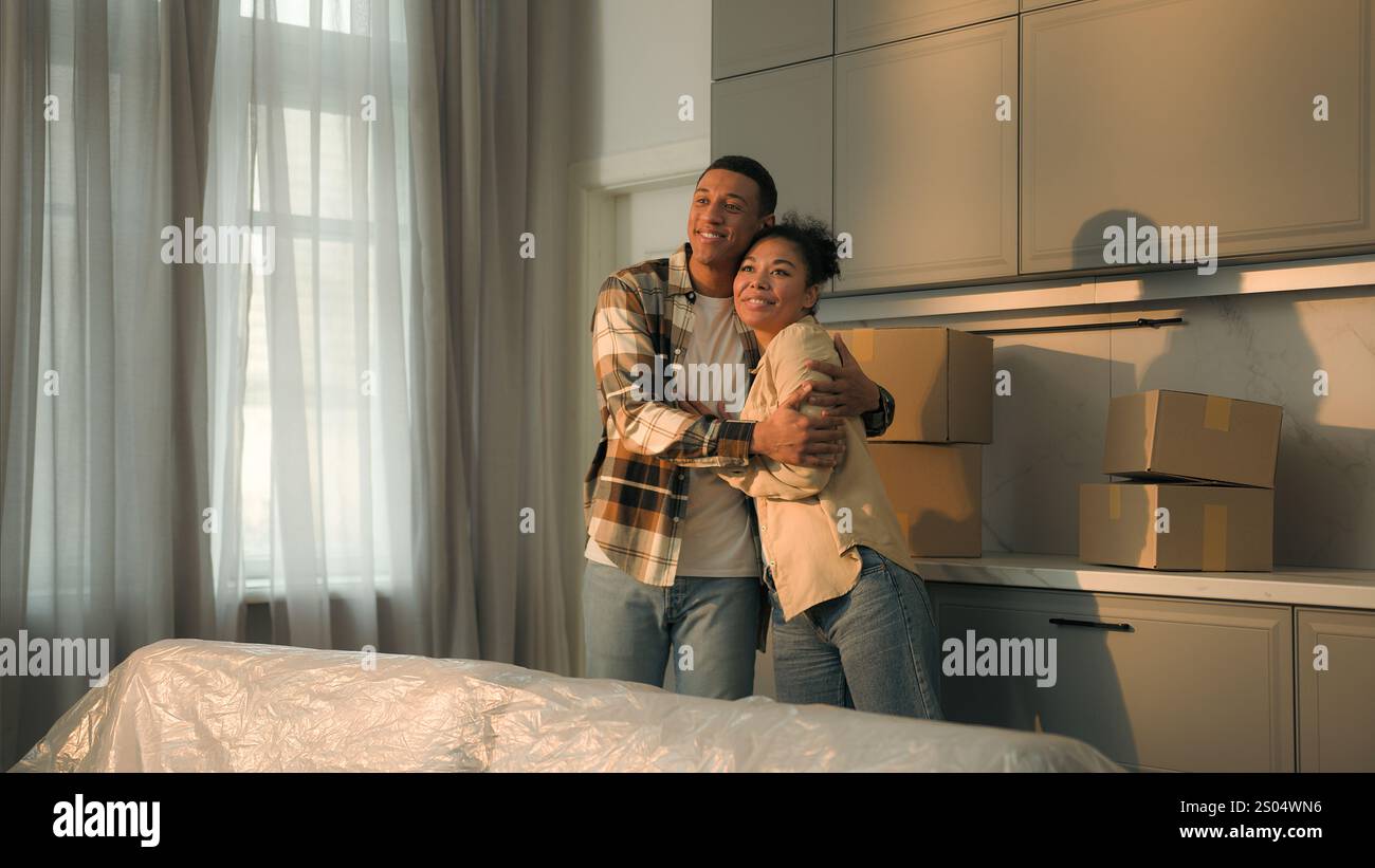 Famiglia afroamericana felice affettuosa coppia proprietari di case affitta uomo donna che si trasferisce in nuovo appartamento trasferimento comprare casa gioiosa maschio femmina Foto Stock