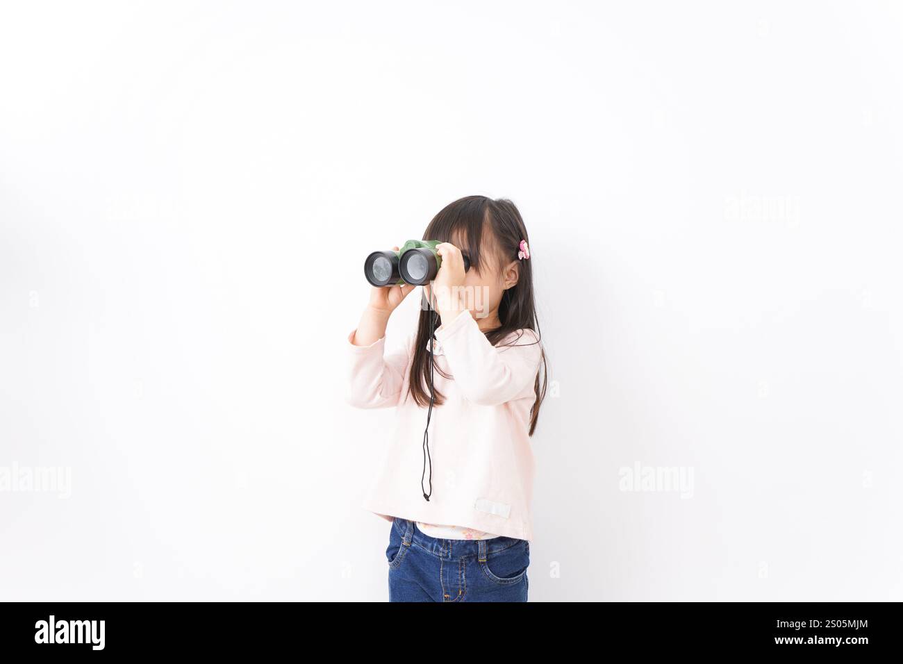 Bambino che usa un binocolo Foto Stock