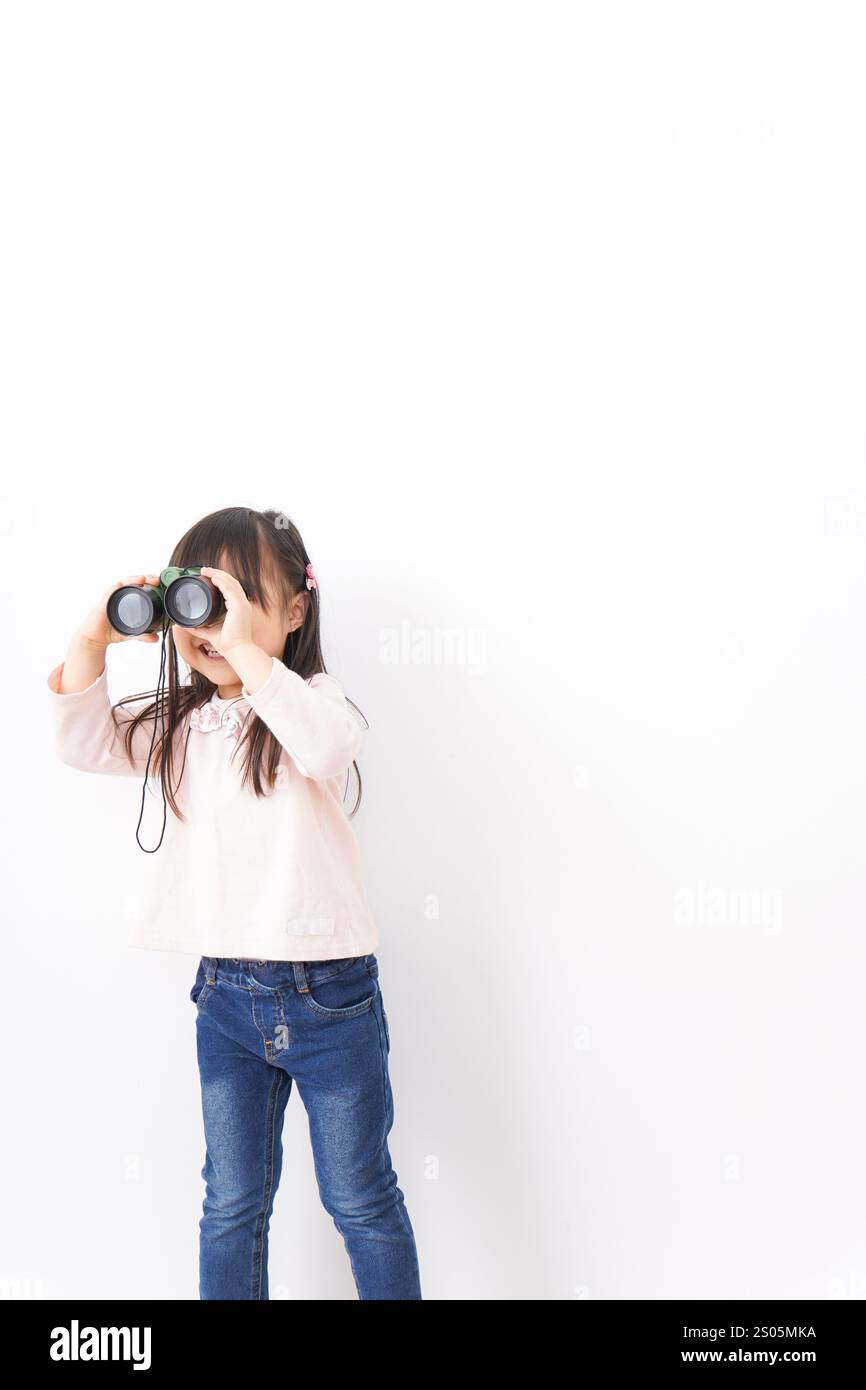 Bambino che usa un binocolo Foto Stock