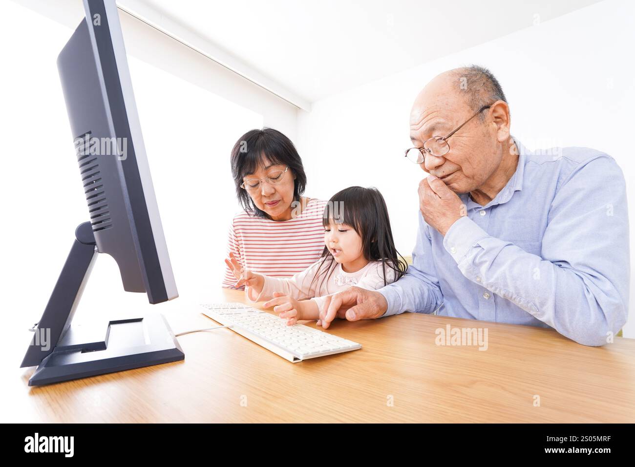 Nonni e figli che usano un computer Foto Stock