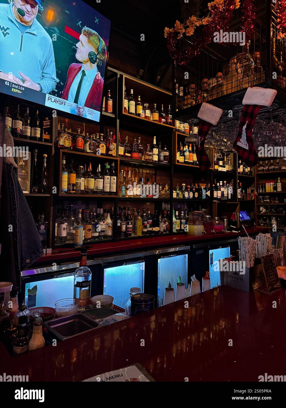 Un invitante ed esclusivo ambiente bar con banchi in legno lucido, vetreria scintillante e cocktail sapientemente preparati, perfetto per una notte di relax. Foto Stock