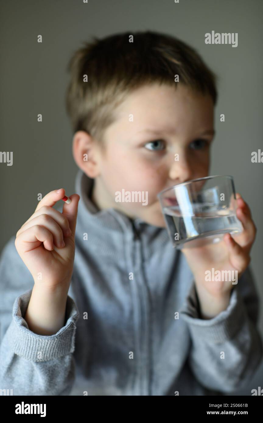 il ragazzo prenderà una pillola di supplemento Foto Stock