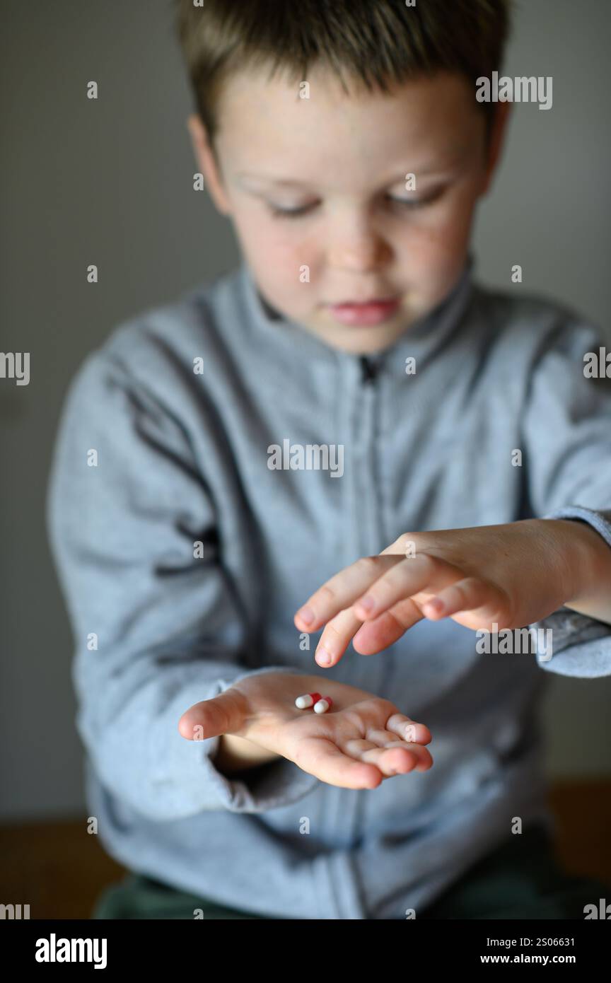 il ragazzo prenderà una pillola di supplemento Foto Stock
