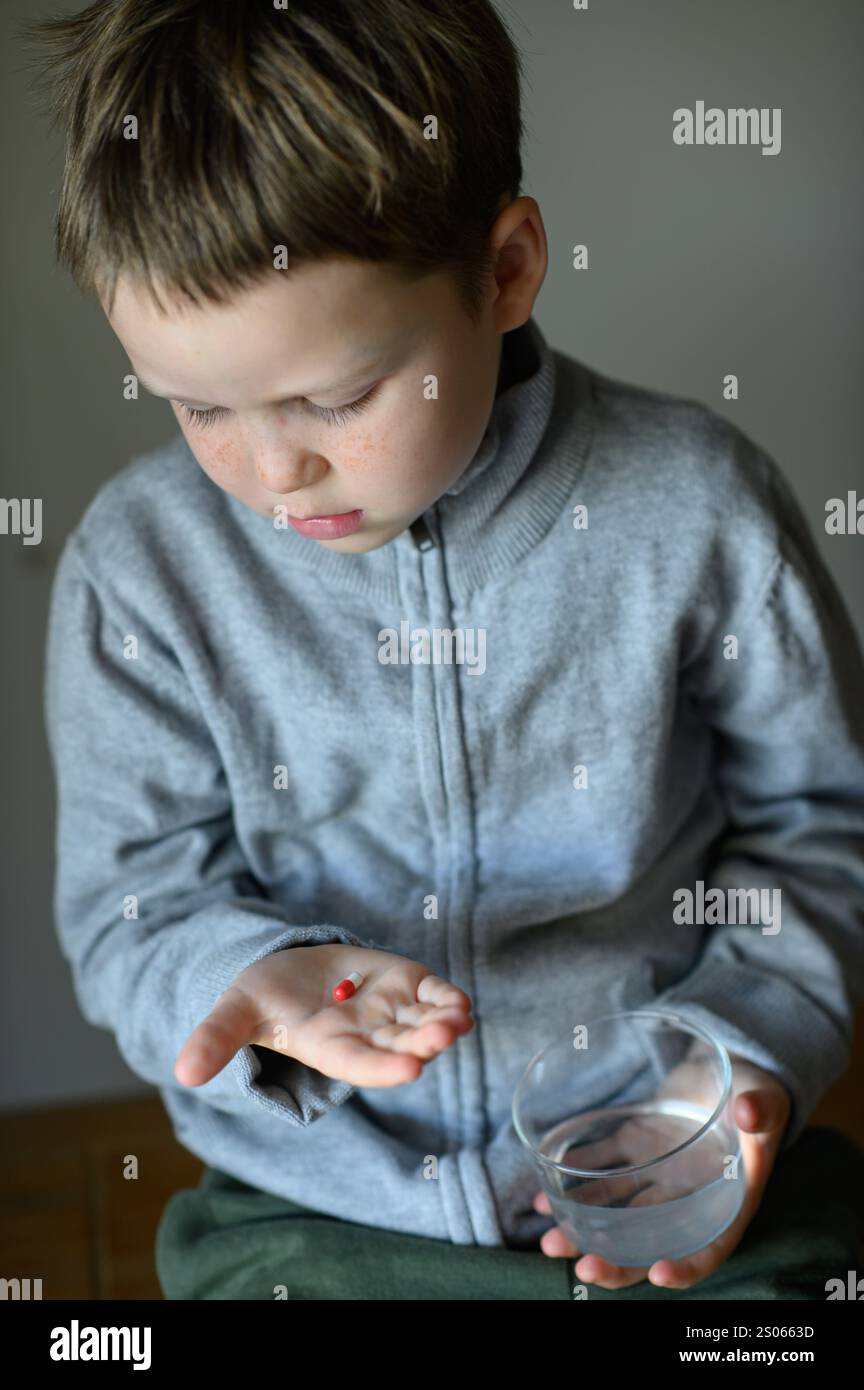 il ragazzo prenderà una pillola di supplemento Foto Stock