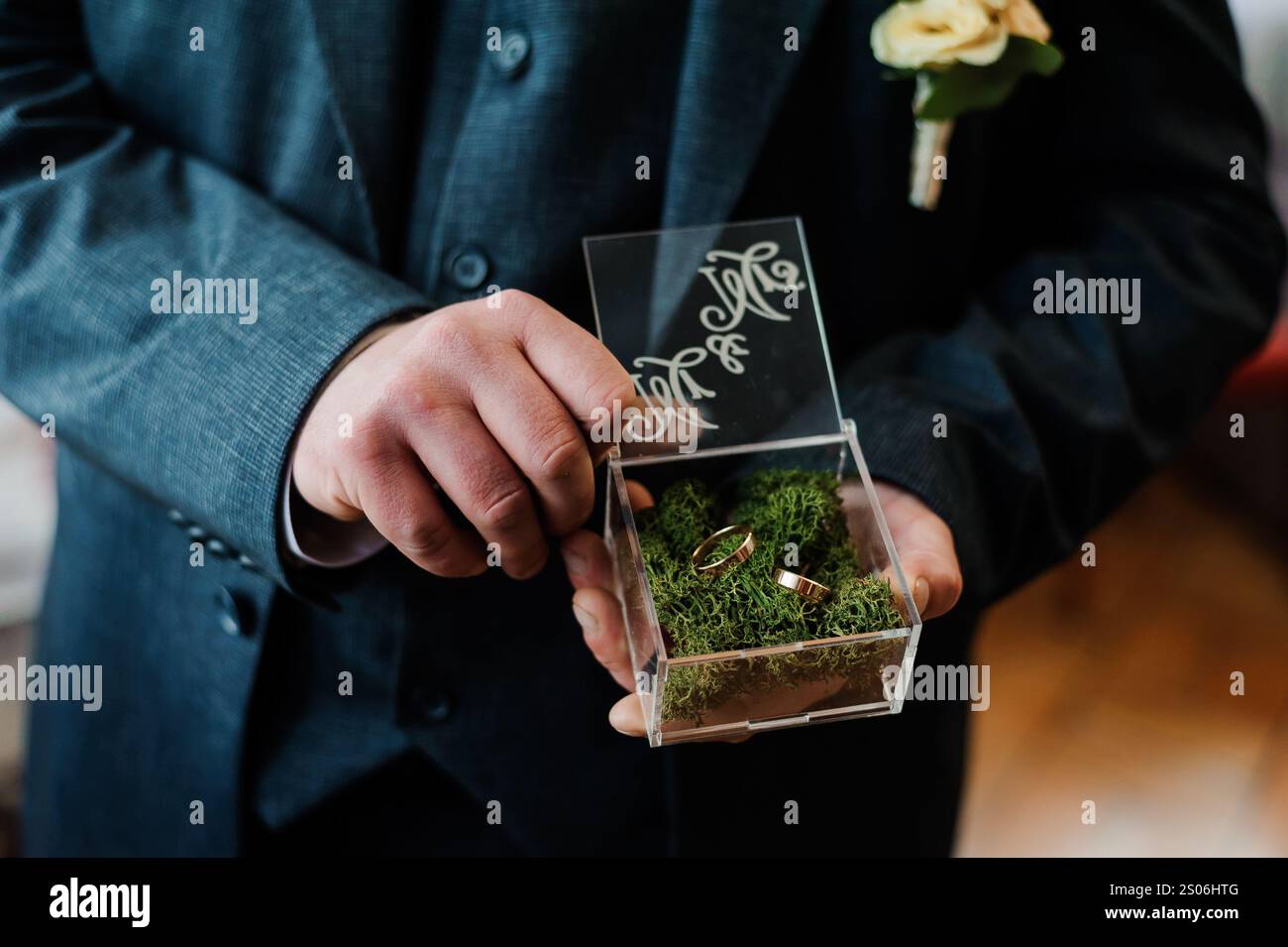 Eleganti anelli da sposa presentati in una scatola decorativa circondata da muschio verde. Foto Stock