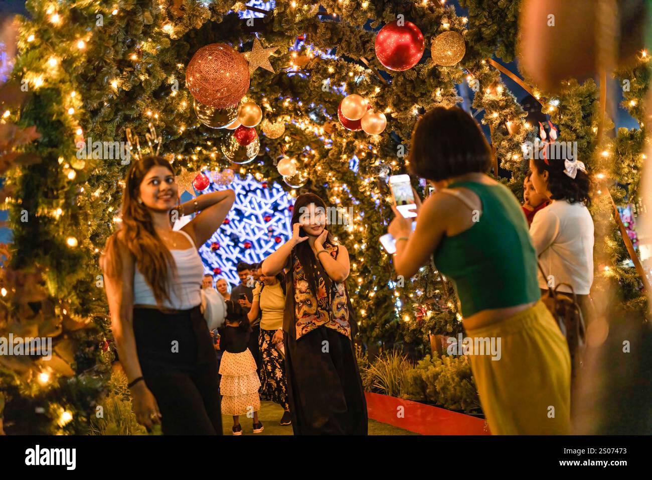 Melbourne, Australia. 25 dicembre 2024. I visitatori apprezzeranno le luci natalizie di Federation Square. La folla celebra la notte di Natale alla stazione Flinders Street di Melbourne, adornata da luci e decorazioni festose, godendosi l'atmosfera vivace e l'allegria estiva. Credito: SOPA Images Limited/Alamy Live News Foto Stock