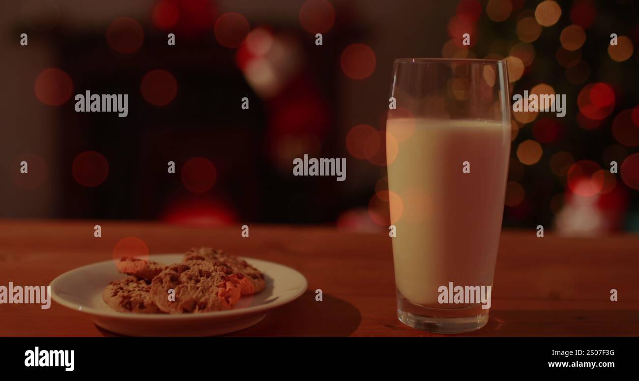 Immagine di un bicchiere di latte e di un piatto di biscotti con luci fairy Foto Stock