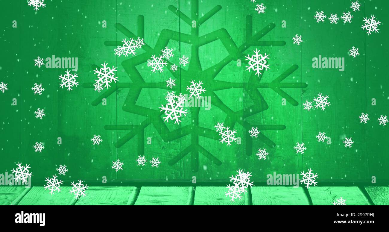 Immagine di fiocchi di neve che cadono sulla tavola di legno contro l'icona del fiocco di neve su sfondo verde Foto Stock