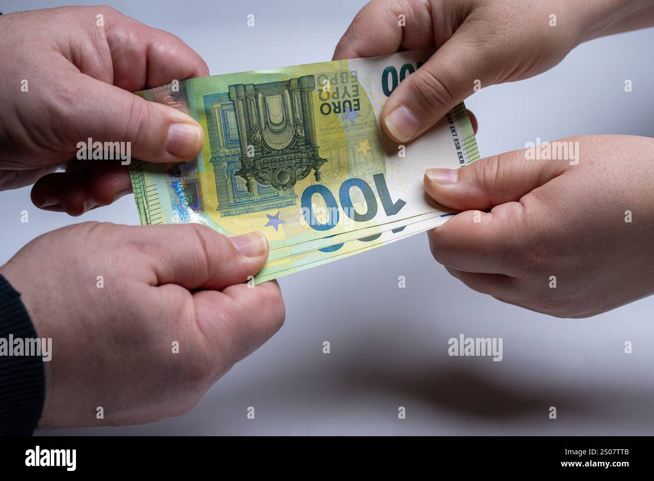 , Deutschland, 26.12.2024, Nahaufnahme von zwei Händen, die um einen 100-Euro-Schein ringen. Symbol für Geldstreit, finanzielle Konflikte oder Zahlun Foto Stock