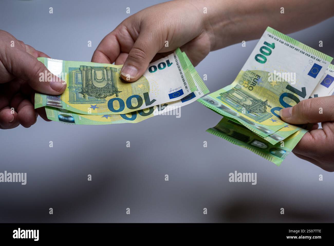 , Deutschland, 26.12.2024, Nahaufnahme von zwei Händen, die mehrere 100-Euro-Scheine bei einer Geldübergabe halten. Symbol für finanzielle Transaktio Foto Stock
