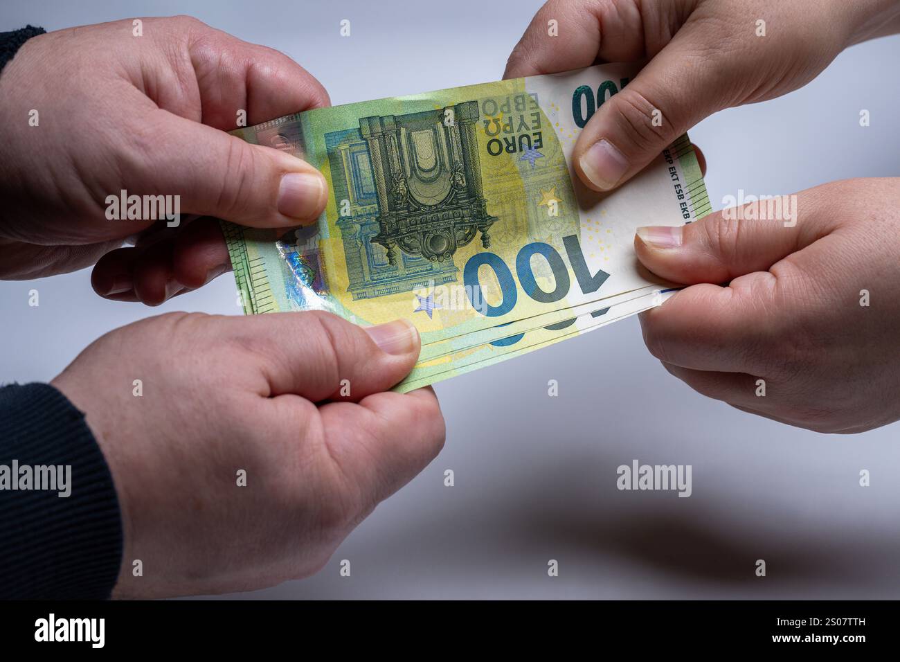 , Deutschland, 26.12.2024, Nahaufnahme von zwei Händen, die um einen 100-Euro-Schein ringen. Symbol für Geldstreit, finanzielle Konflikte oder Zahlun Foto Stock