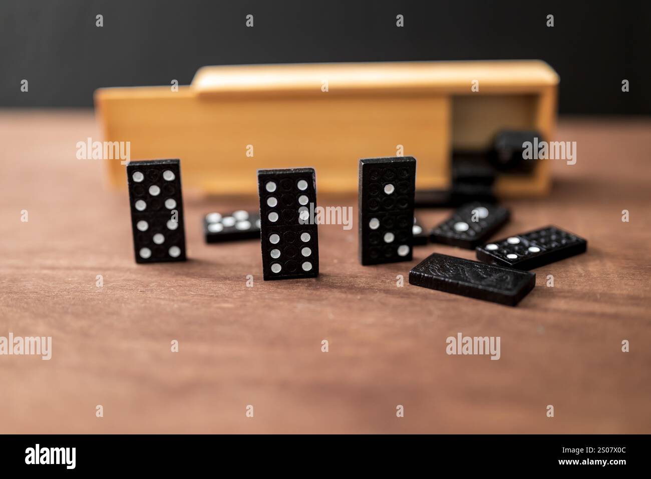 una scatola di piastrelle a domino su un tavolo di legno Foto Stock