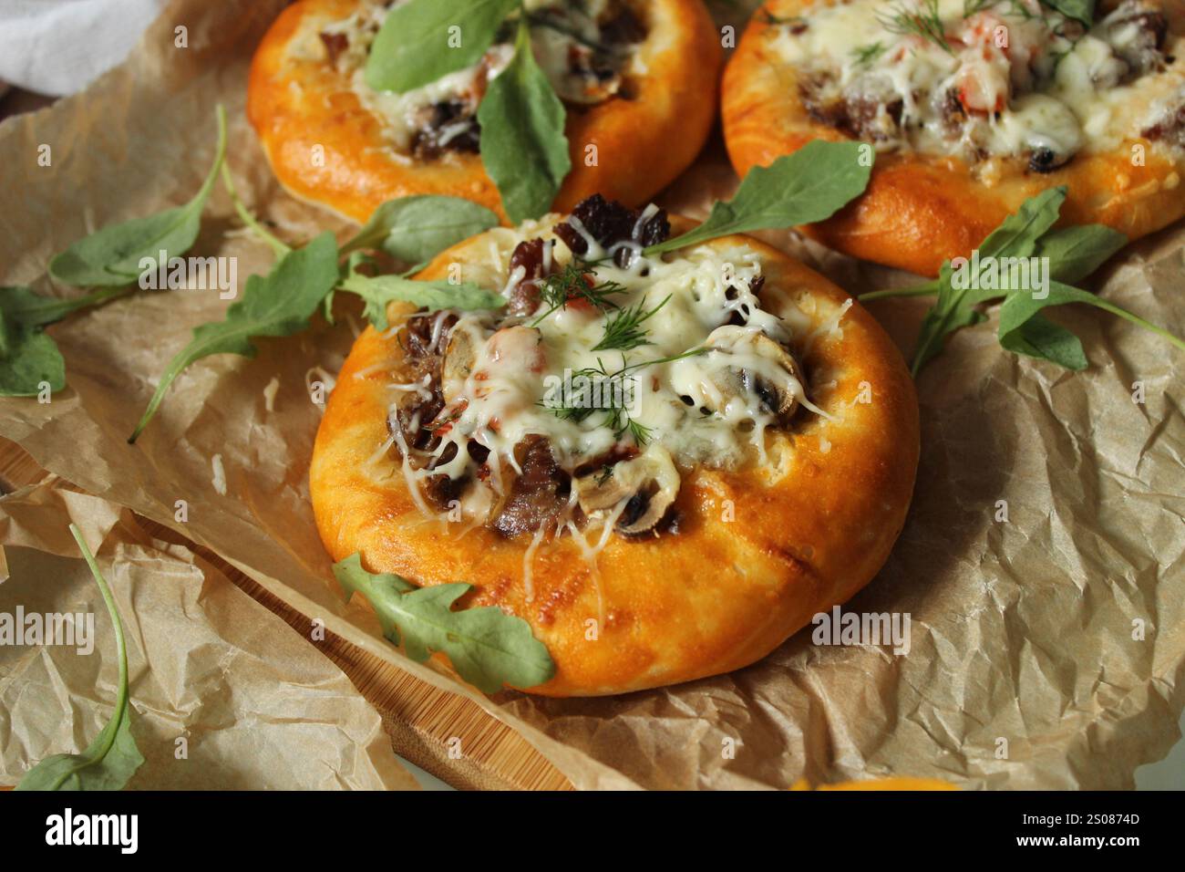 Deliziose mini pizze guarnite con rucola fresca, cotte alla perfezione e pronte da gustare Foto Stock