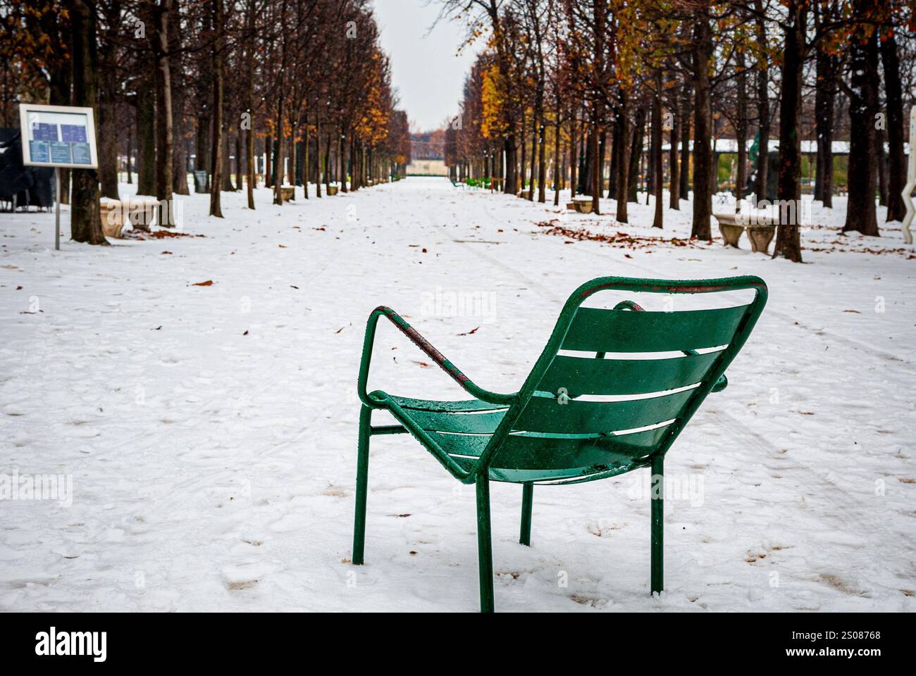 Sedia vuota di metallo verde in piedi nel Jardin des Tuileries nel cuore di Parigi, in Francia, molta neve Foto Stock