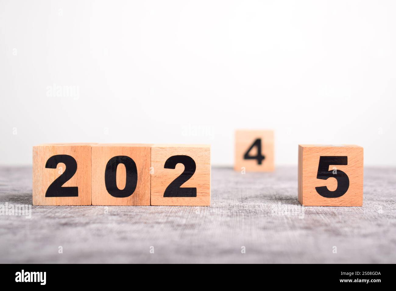 cambio di 2024 anni a 2025 anni per i cubi di legno. passaggio al nuovo anno, che rappresenta il cambiamento, il progresso e il viaggio del tempo in corso Foto Stock