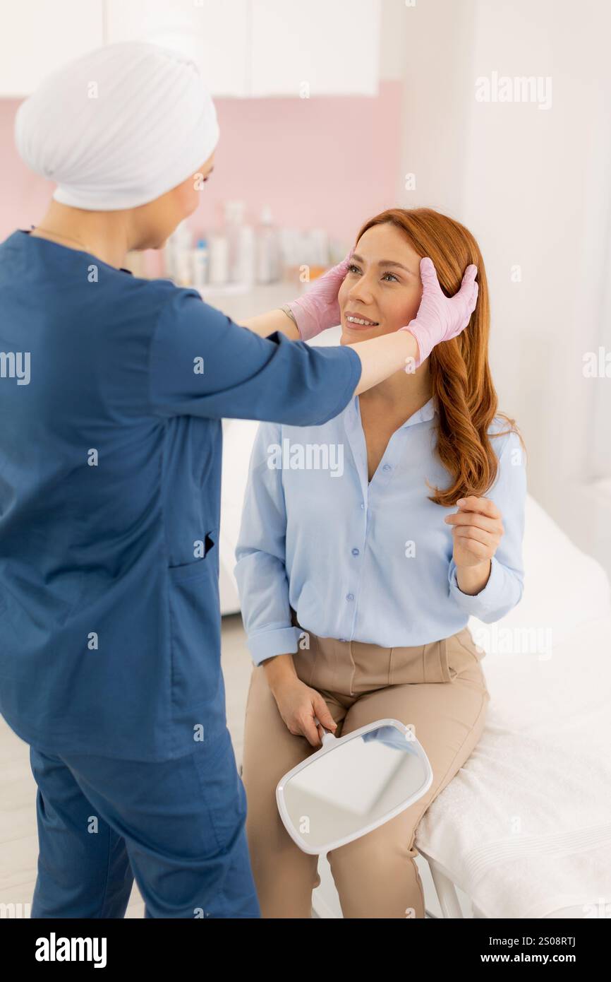 In un rilassante ambiente termale, un professionista della cura della pelle guida un cliente attraverso una consulenza per trattamenti cosmetici, discutendo tecniche e risultati desiderati Foto Stock