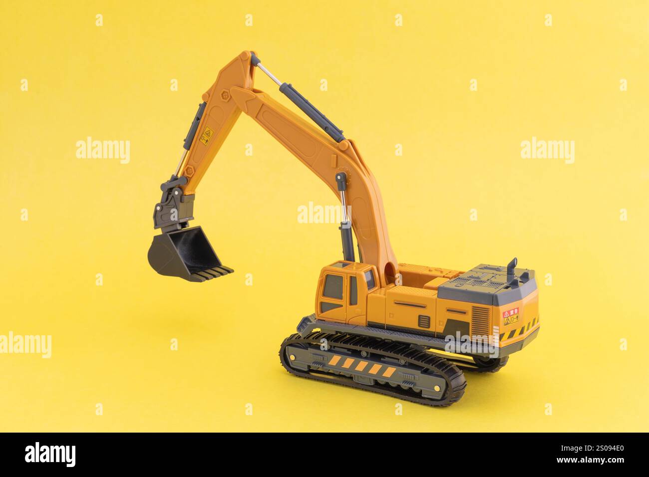 Escavatore giocattolo o scavatore su sfondo giallo. Concetto di veicolo per costruzioni pesanti. Foto Stock