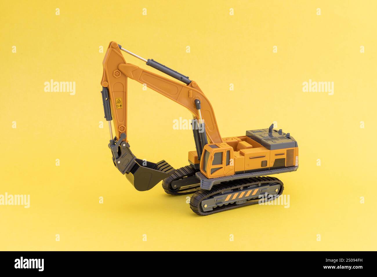 Primo piano di un modello di escavatore isolato su sfondo giallo Foto Stock