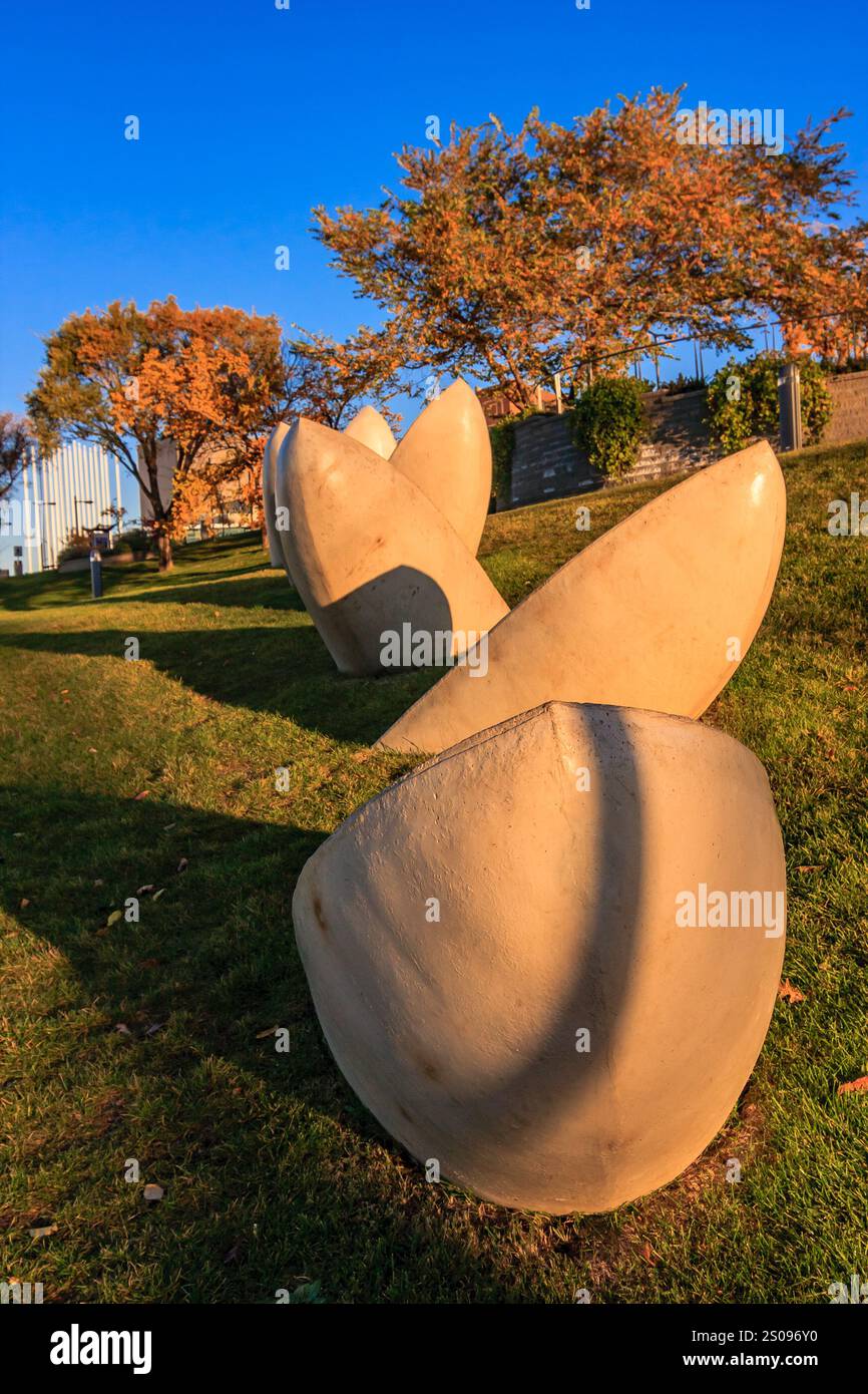 Un gruppo di sculture è seduto su una collina erbosa. Le sculture sono tutte di forme e dimensioni diverse e sono tutte rivolte nella stessa direzione Foto Stock