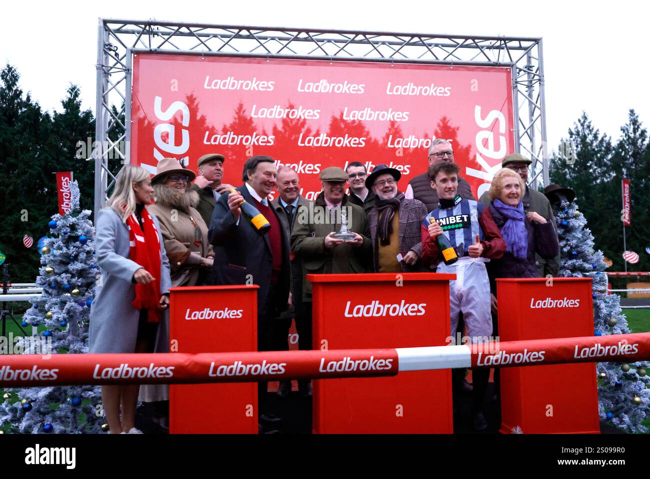 Jockey Freddie Gordon (terzo a destra) e l'allenamento Nicky Henderson (quarto a sinistra) festeggiano dopo aver vinto il Ladbrokes 'Gaffer of All Accas' Maiden hurdle con cavallo East India Express nel King George vi Chase Day al Kempton Park Racecourse, Sunbury-on-Thames, Surrey. Data foto: Giovedì 26 dicembre 2024. Foto Stock