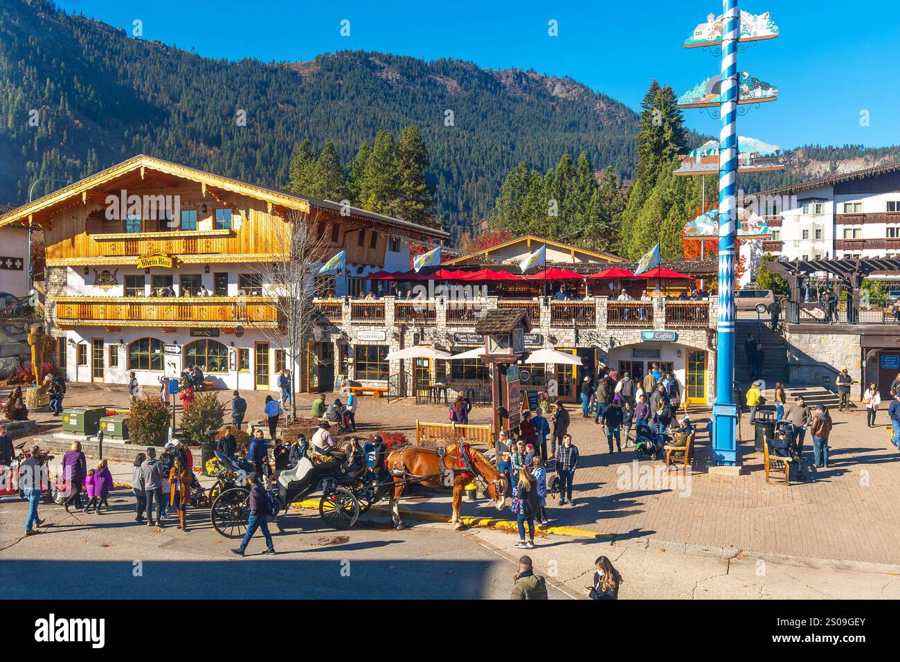 Negozi e caffetterie lungo il marciapiede fiancheggiano la pittoresca strada principale a tema bavarese della località turistica di Leavenworth, tra le montagne del centro di Washington Foto Stock