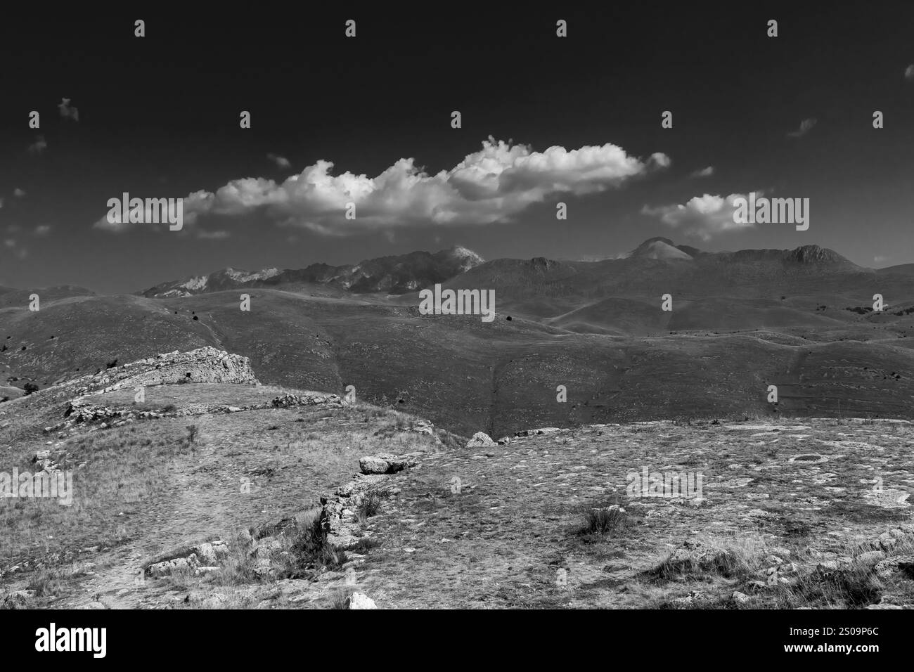 Paesaggio bianco e nero con cieli spettacolari e colline aride, catturando la bellezza senza tempo e l'essenza pura della natura Foto Stock