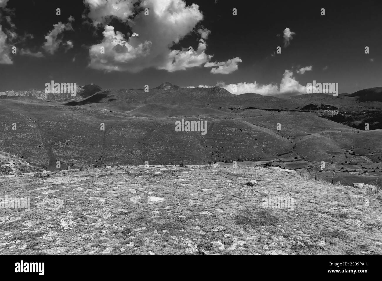 Paesaggio bianco e nero con cieli spettacolari e colline aride, catturando la bellezza senza tempo e l'essenza pura della natura Foto Stock