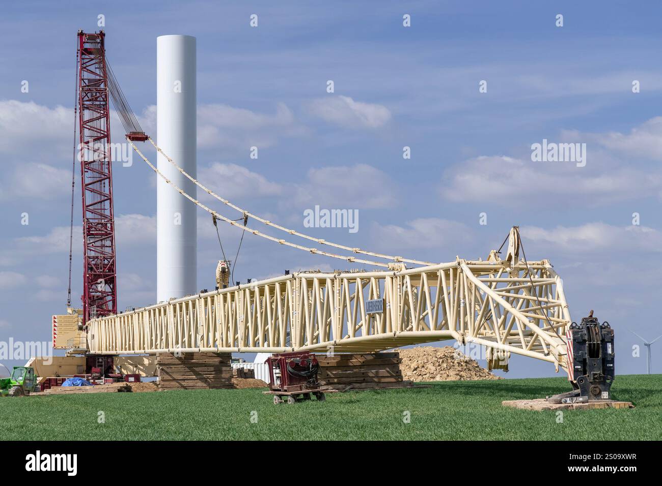 Nancy, Francia - Vista su una gru Beige e Borgogna lattice boom Liebherr LG 1750 nel cantiere di un parco eolico. Foto Stock