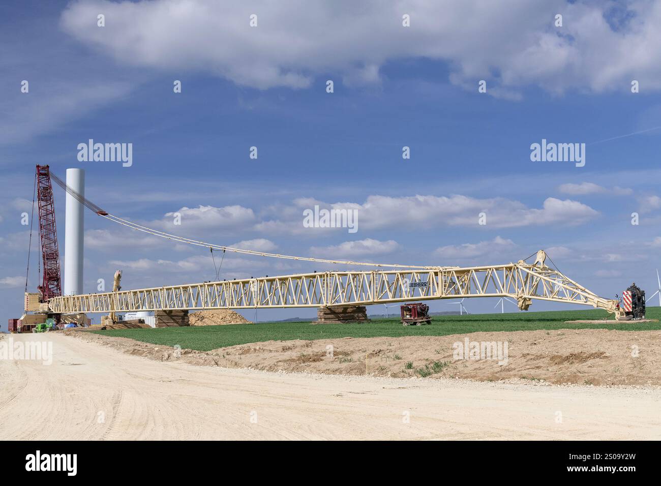 Nancy, Francia - Vista su una gru Beige e Borgogna lattice boom Liebherr LG 1750 nel cantiere di un parco eolico. Foto Stock