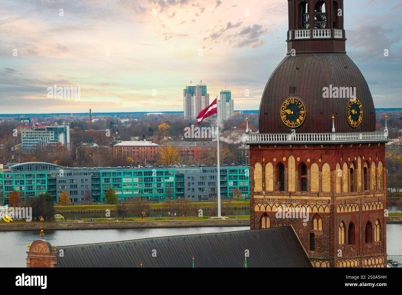 L'immagine cattura una vista aerea di riga, Lettonia, evidenziando la cattedrale di riga con la sua torre dell'orologio. Gli edifici moderni e il fiume Daugava sono vi Foto Stock