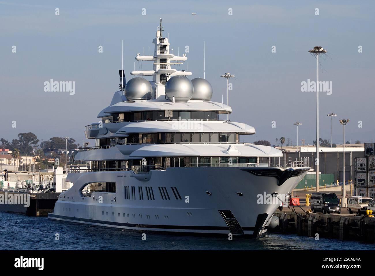 San Diego, California, Stati Uniti. 21 dicembre 2024. Superyacht *Amadea* attraccato a San Diego, che presenta il suo design elegante e la sua opulenta struttura multi-deck contro il fronte industriale del mare. Con una lunghezza impressionante di piedi (106 metri), questa nave da 348 milioni dispone di un eliporto, una piscina, interni sontuosi e sistemazioni per un massimo di 16 ospiti e 36 membri dell'equipaggio. Sequestrato dal governo degli Stati Uniti a causa dei suoi legami con l'applicazione delle sanzioni russe, lo yacht è stato al centro di controversie, con rapporti che evidenziano i significativi costi di manutenzione'''' che si aggirano su milioni di dollari all'anno Foto Stock