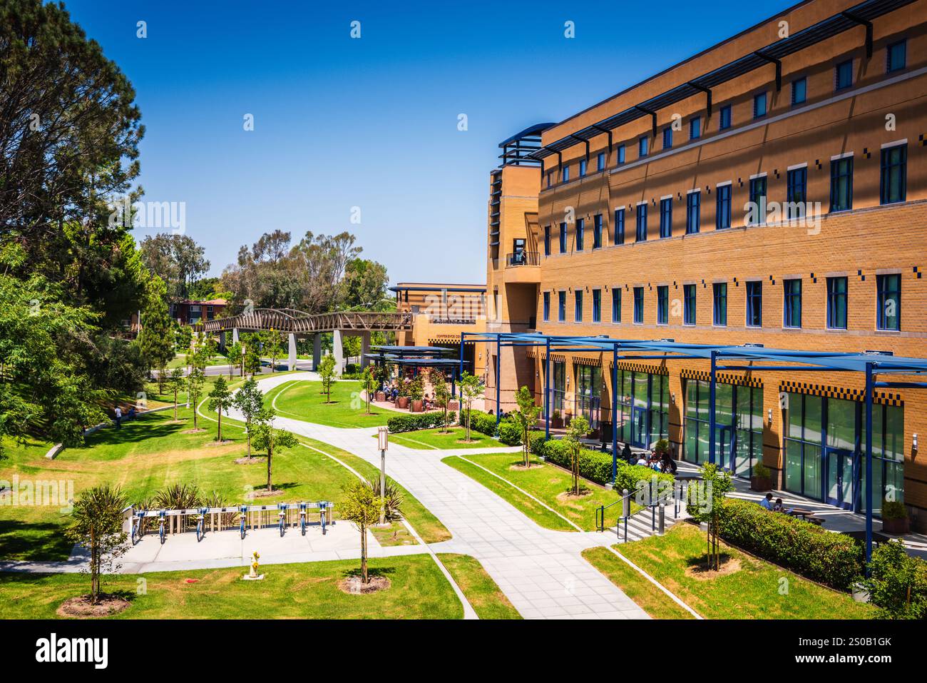 Irvine CA USA - 10 agosto 2017: Passerella, prato e portabiciclette presso l'Università della California presso il campus di Irvine (UCI). Foto Stock