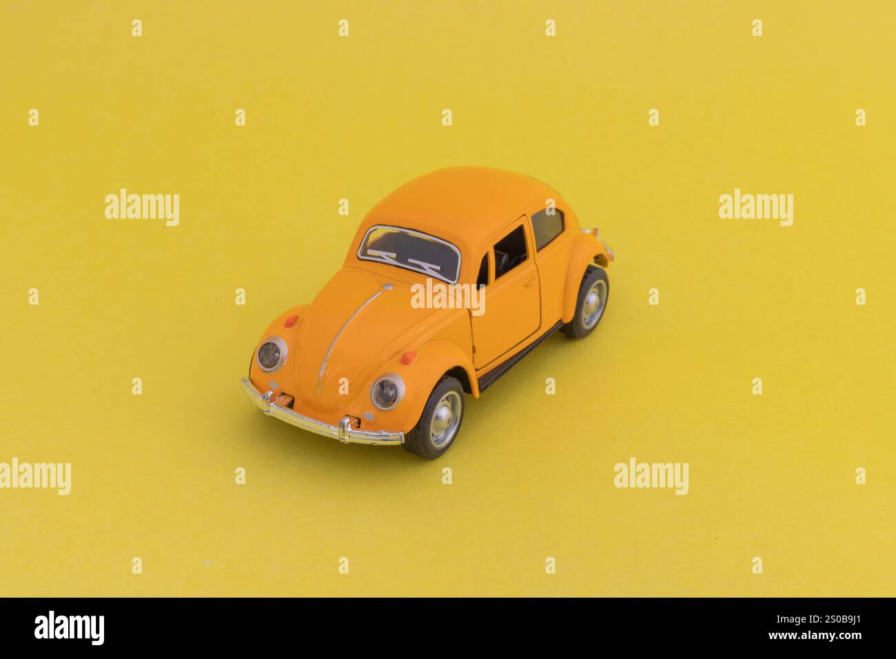 Giocattolo Volkswagen Beetle su sfondo giallo. Foto Stock