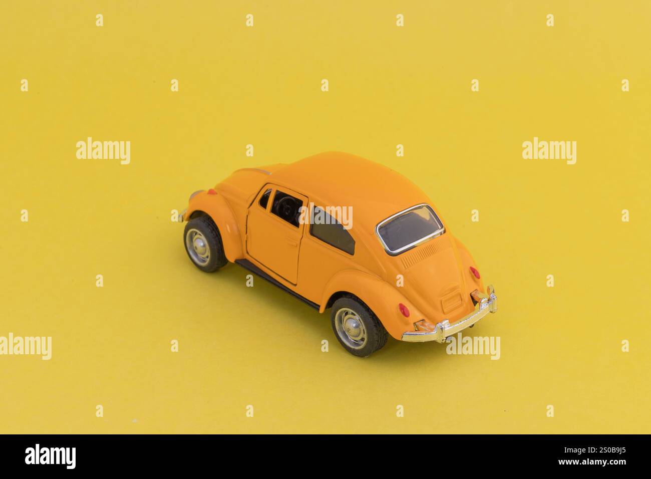 Un'auto giocattolo VW d'epoca gialla su sfondo giallo Foto Stock