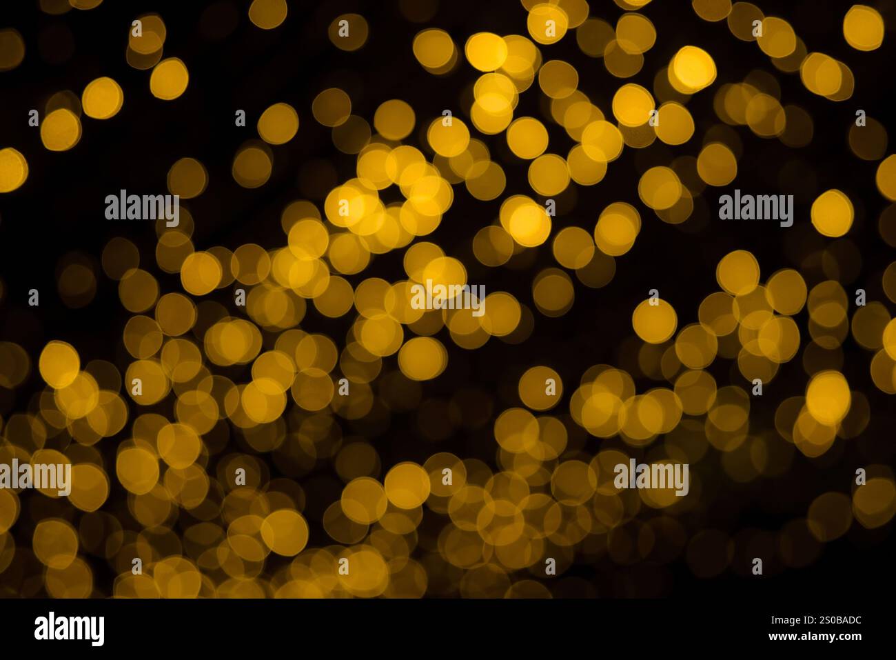 molti bokeh provenienti dai tubi delle lampadine di una strada di notte sembrano luci dorate di lusso su uno sfondo scuro Foto Stock