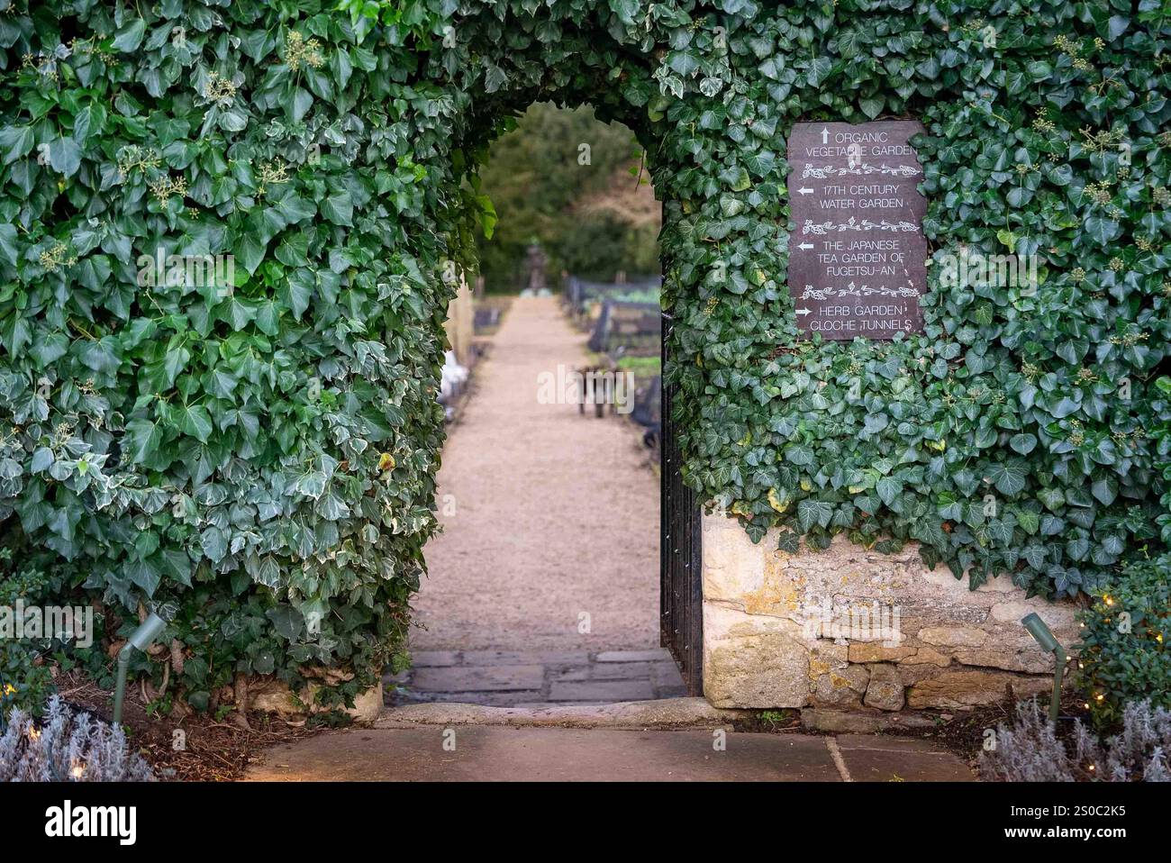 Porta ad arco rivestita di edera all'orto di le Manoir aux Quat'Saisons Foto Stock