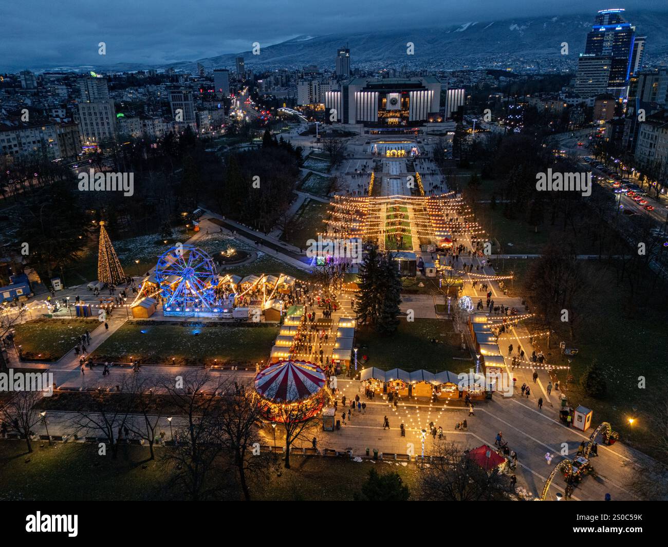 Vista aerea del Palazzo Nazionale della Cultura (NDK) a Sofia, Bulgaria, con mercatino di Natale illuminato con ruota panoramica e luci festive. Foto Stock