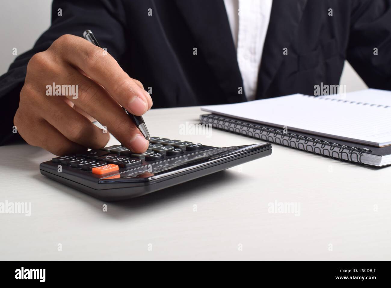 Il commercialista analizza il grafico degli investimenti in fattura e preme il pulsante del calcolatore sul documento. Contabile consulente bancario e revisore contabile. Foto Stock