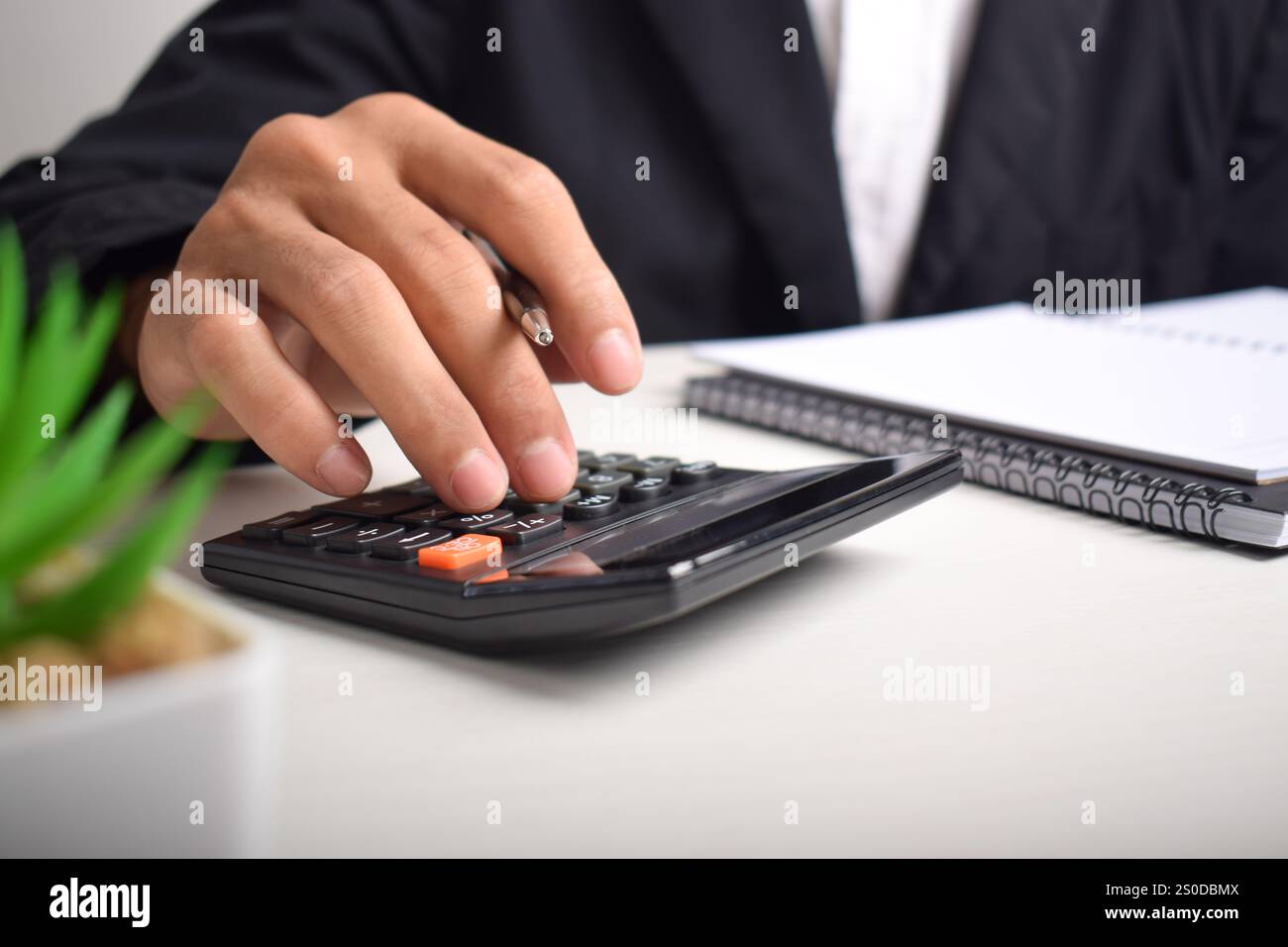 Il commercialista analizza il grafico degli investimenti in fattura e preme il pulsante del calcolatore sul documento. Contabile consulente bancario e revisore contabile. Foto Stock