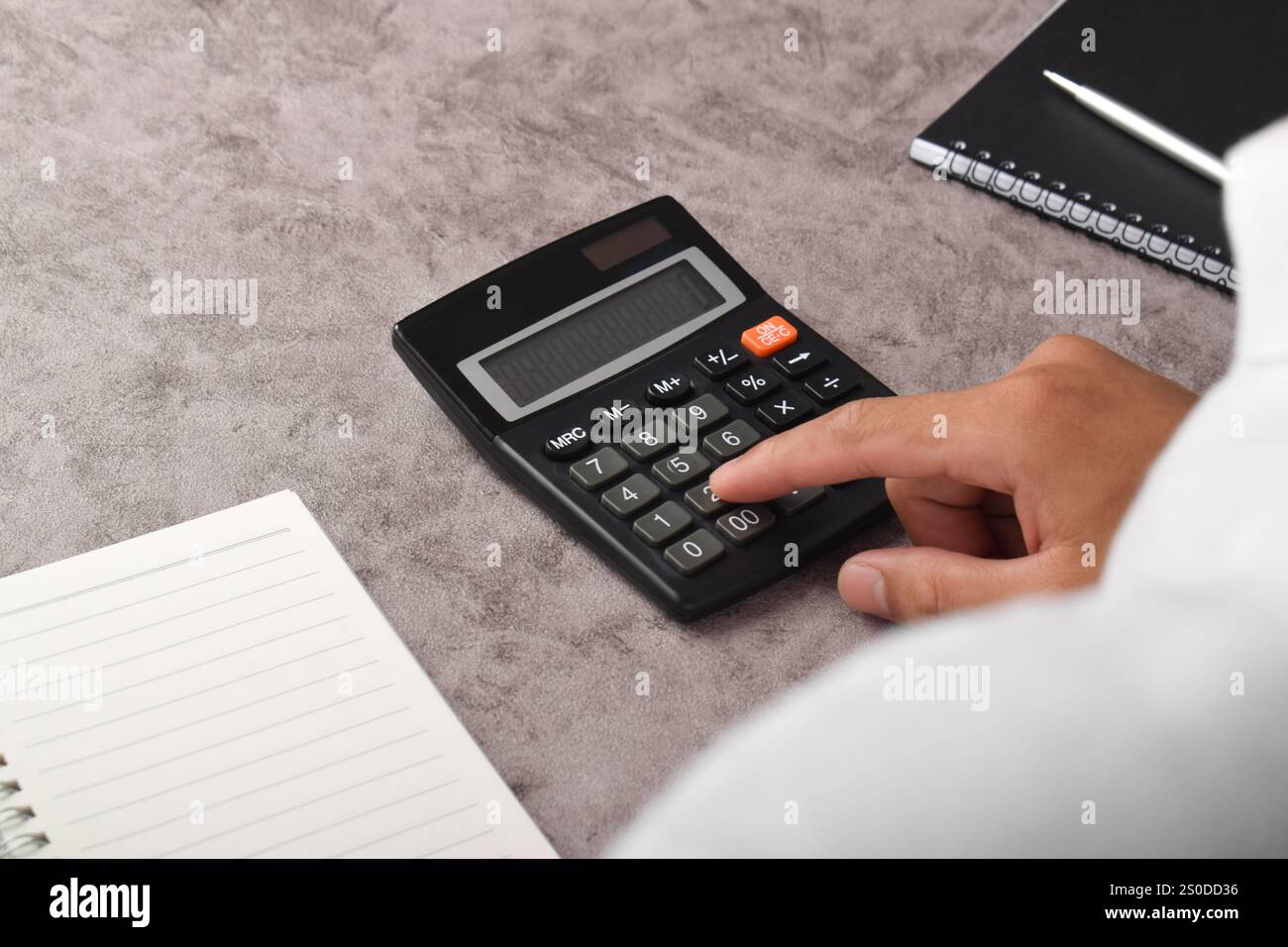 Primo piano delle mani di un uomo d'affari usando una calcolatrice in ufficio Foto Stock