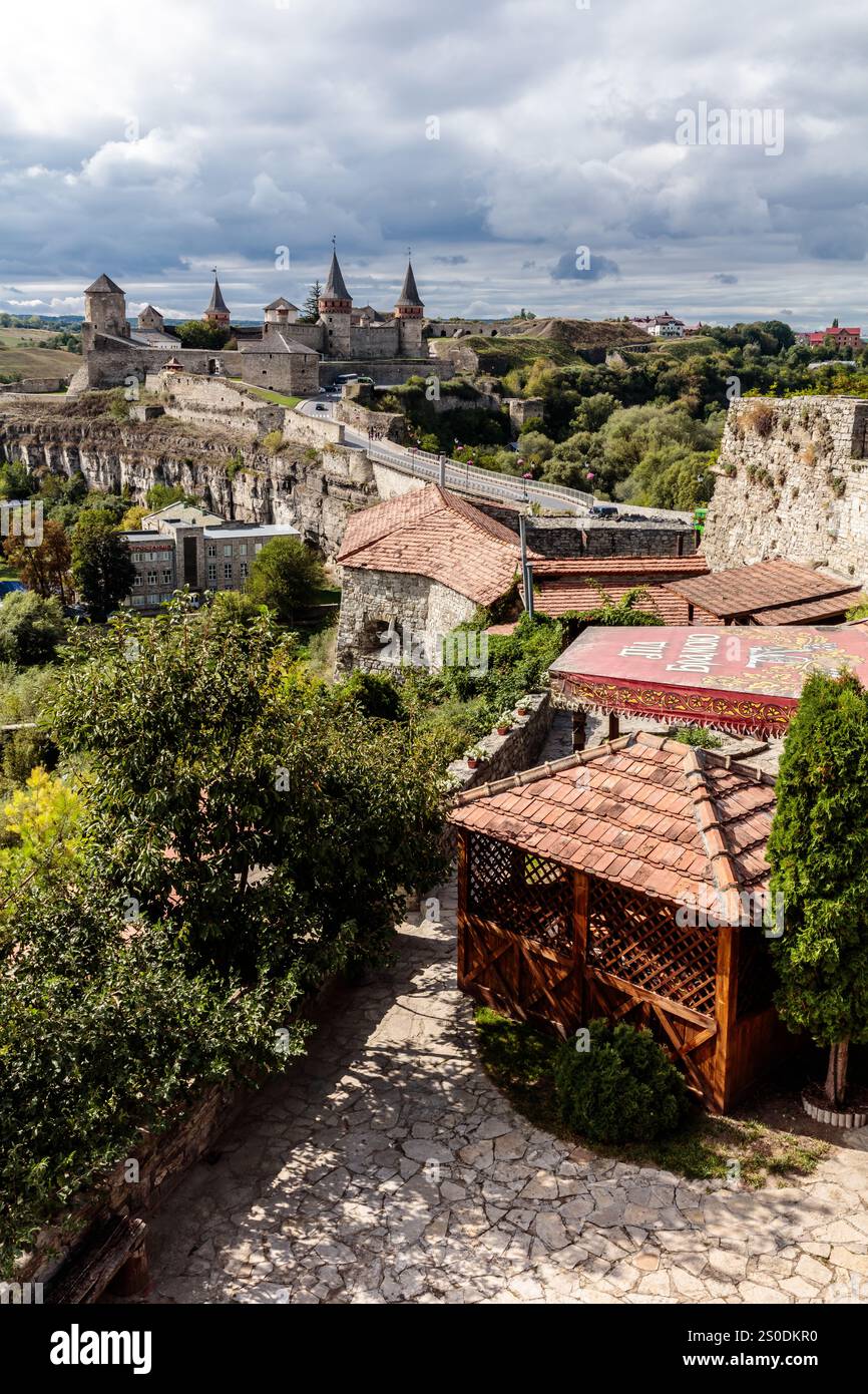 Una vista di una città con un grande castello sullo sfondo. Il castello è circondato da alberi ed edifici Foto Stock