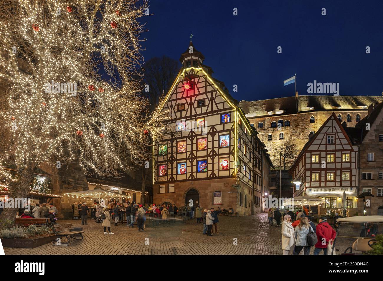 Pilkatushaus storico con un calendario dell'Avvento il 18 dicembre 2024 al crepuscolo, dietro il Castello Imperiale, Tiergaertnertorplatz, Norimberga, Franco medio Foto Stock