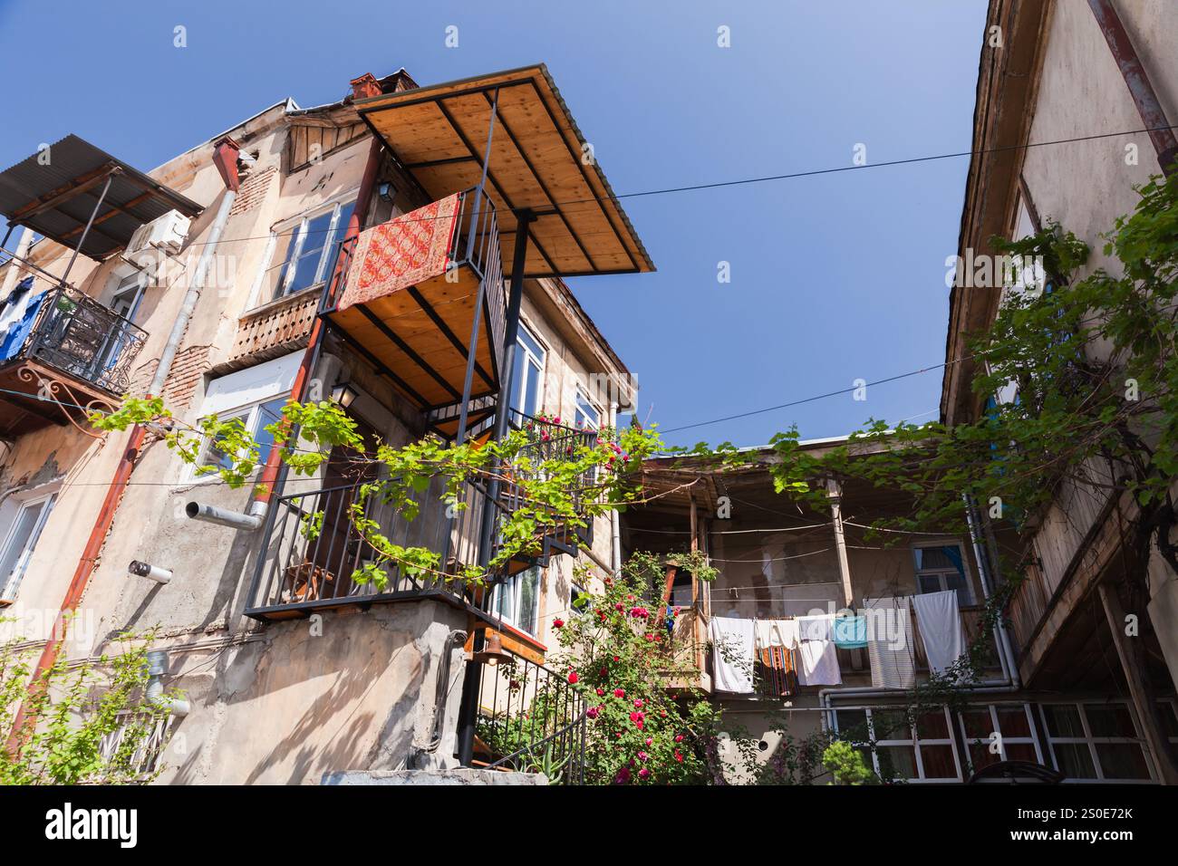 Vista sulla vecchia via Tbilisi con balconi di piccole case in una giornata di sole Foto Stock