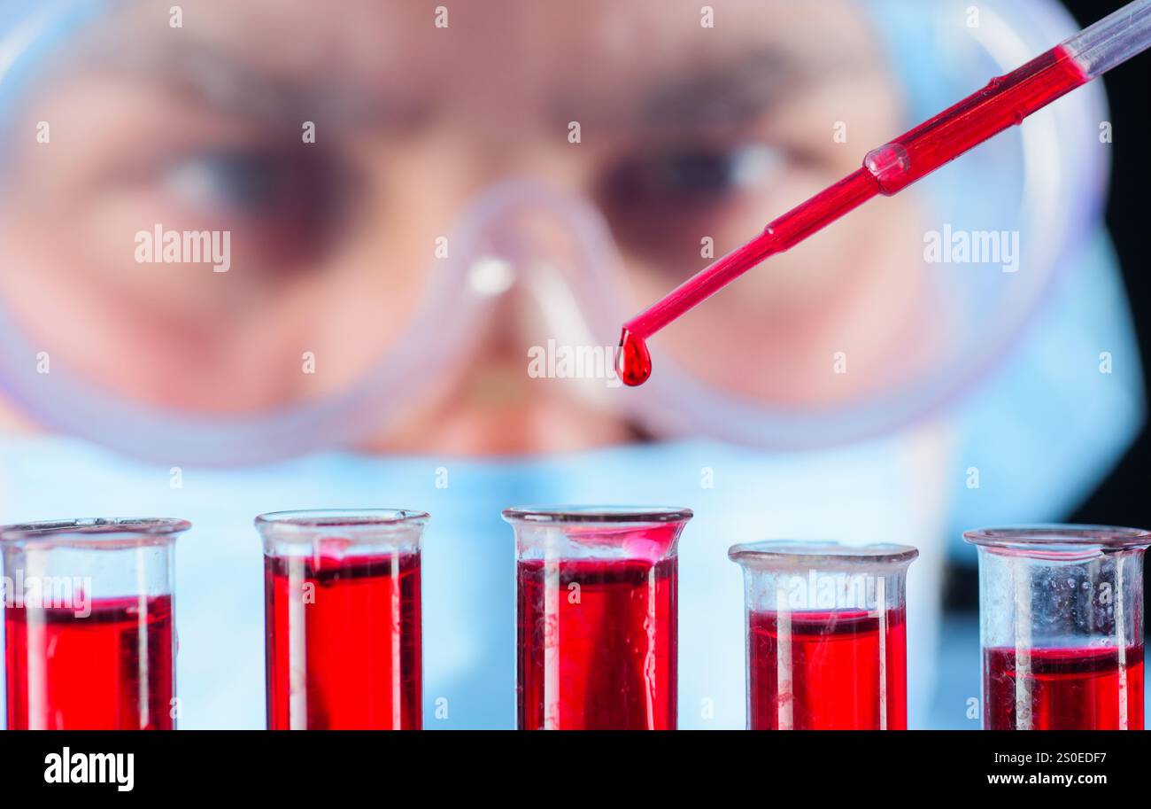 Analisi del sangue. Medico che lavora con il campione di sangue del paziente in laboratorio. Test sierologici in ospedale. Scienziato medico o assistente di laboratorio in maschera e. Foto Stock