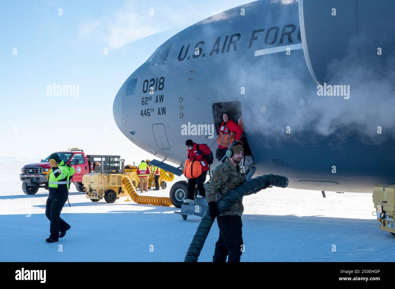 I capi dell'equipaggio di volo McChord della U.S. Air Force Team, e il personale addetto alle attrezzature di terra dell'aeroporto della National Science Foundation attaccano i riscaldatori ai motori di un C-17 Globemaster III, assegnato al 62d Airlift Wing, presso Phoenix Airfield, Antartide, 22 ottobre 2024. La U.S. National Science Foundation gestisce il programma antartico degli Stati Uniti e sostiene la ricerca scientifica supervisionando un massiccio sforzo di cooperazione tra ricercatori, agenzie militari e civili. (Foto U.S. Air Force di Senior Airman Colleen Anthony) Foto Stock