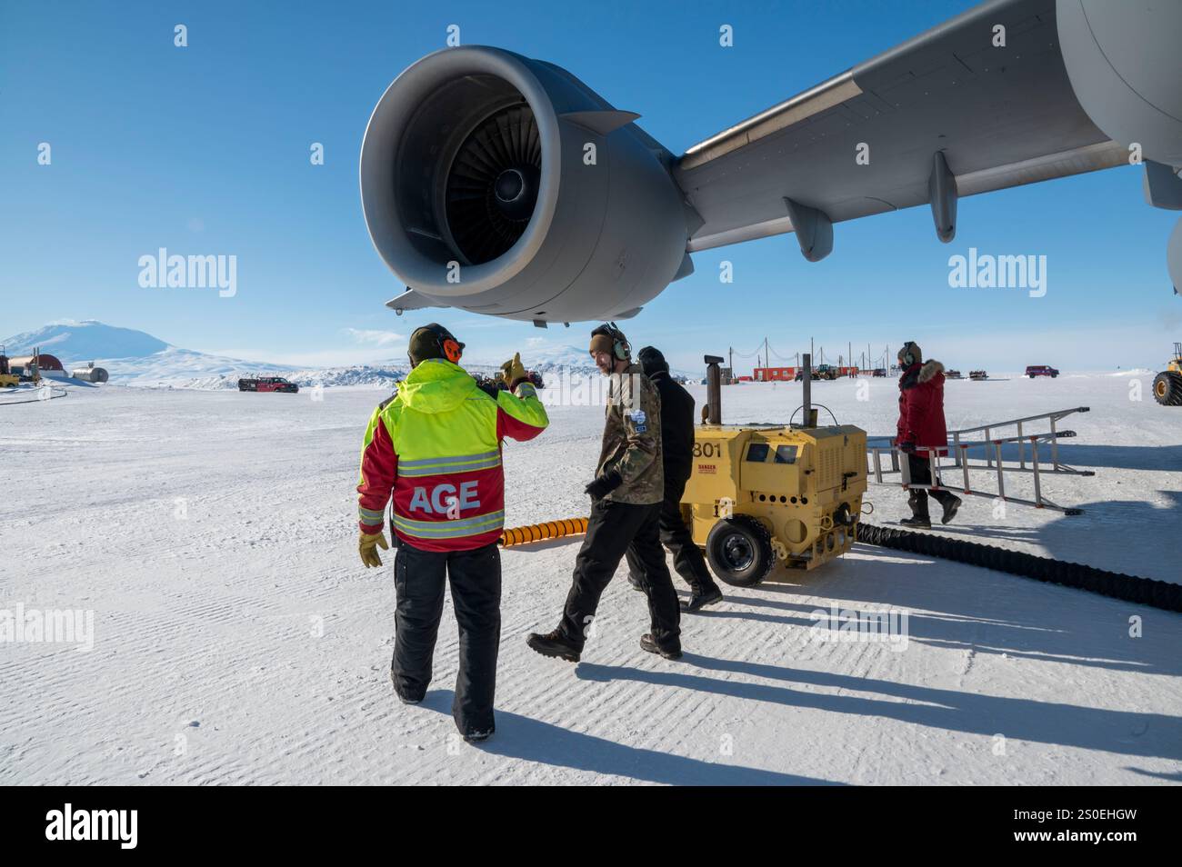 I capi dell'equipaggio di volo McChord del team dell'aeronautica statunitense e il personale addetto alle attrezzature di terra della National Science Foundation attaccano i riscaldatori ai motori di un C-17 Globemaster III, assegnato al 62d Airlift Wing, presso Phoenix Airfield, Antartide, 22 ottobre 2024. La NSF gestisce il programma antartico degli Stati Uniti e sostiene la ricerca scientifica supervisionando un massiccio sforzo di cooperazione tra ricercatori, agenzie militari e civili. (Foto U.S. Air Force di Senior Airman Colleen Anthony) Foto Stock
