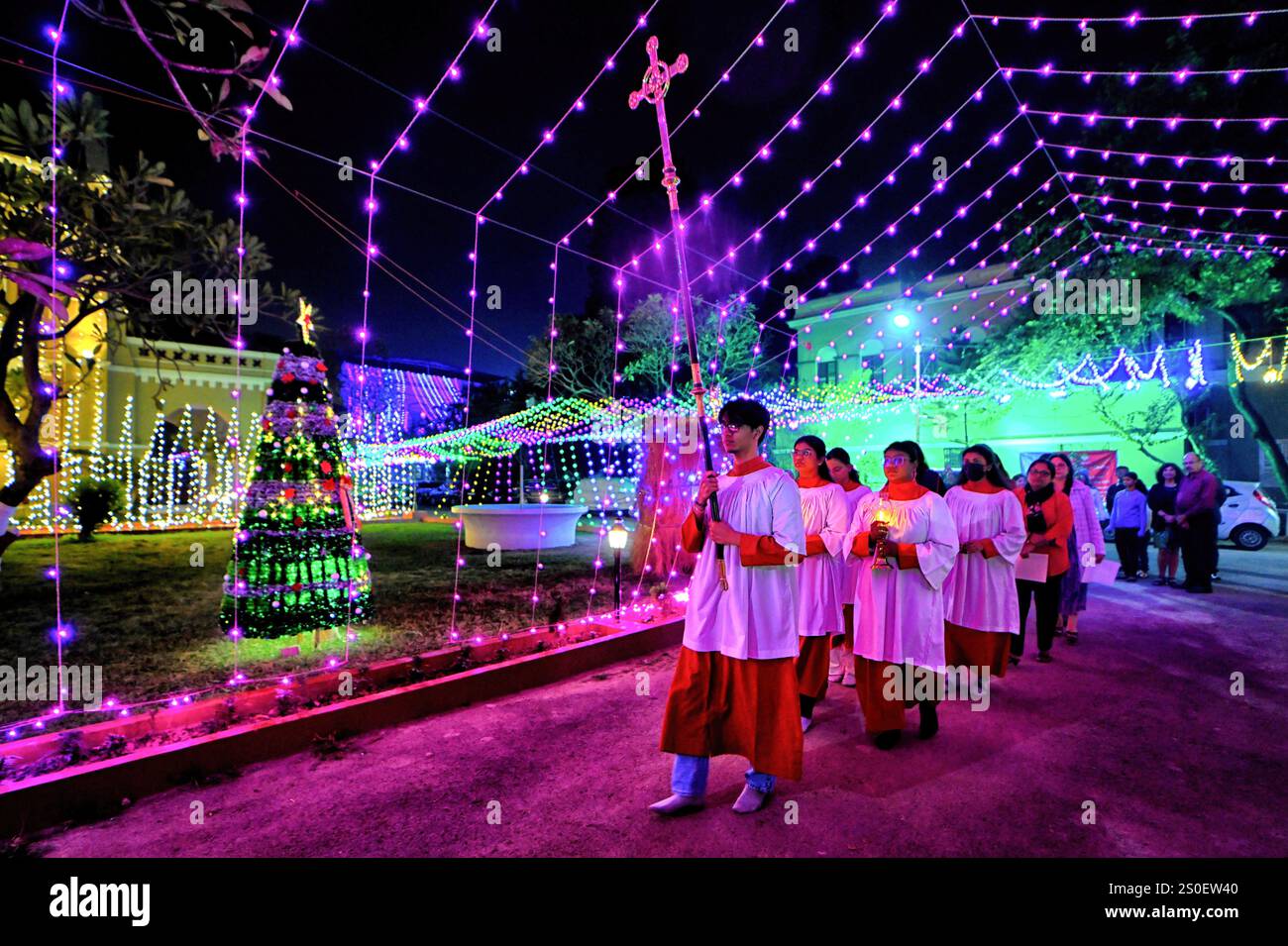 Kolkata, India. 24 dicembre 2024. I membri della Chiesa di San Giacomo hanno visto portare la croce prima della messa di mezzanotte a Kolkata. Preghiera di mezzanotte con candele in occasione del Natale alla chiesa di San Giacomo. Il Natale è un festival annuale che celebra la nascita di Gesù Cristo, celebrato in tutto il mondo. Credito: SOPA Images Limited/Alamy Live News Foto Stock