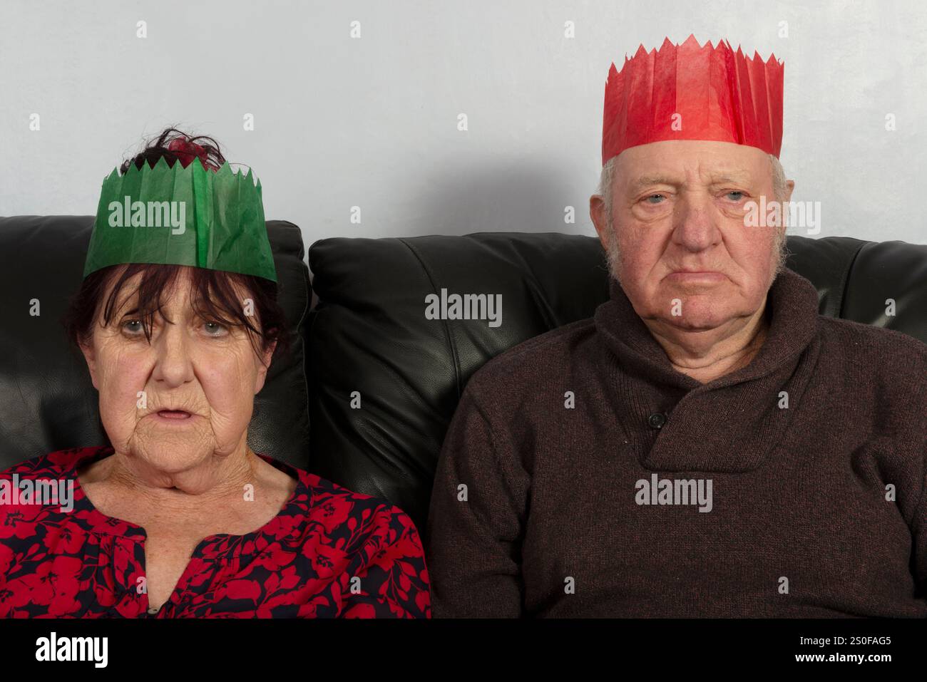 Una coppia anziana che indossa cappelli di carta di Natale Foto Stock